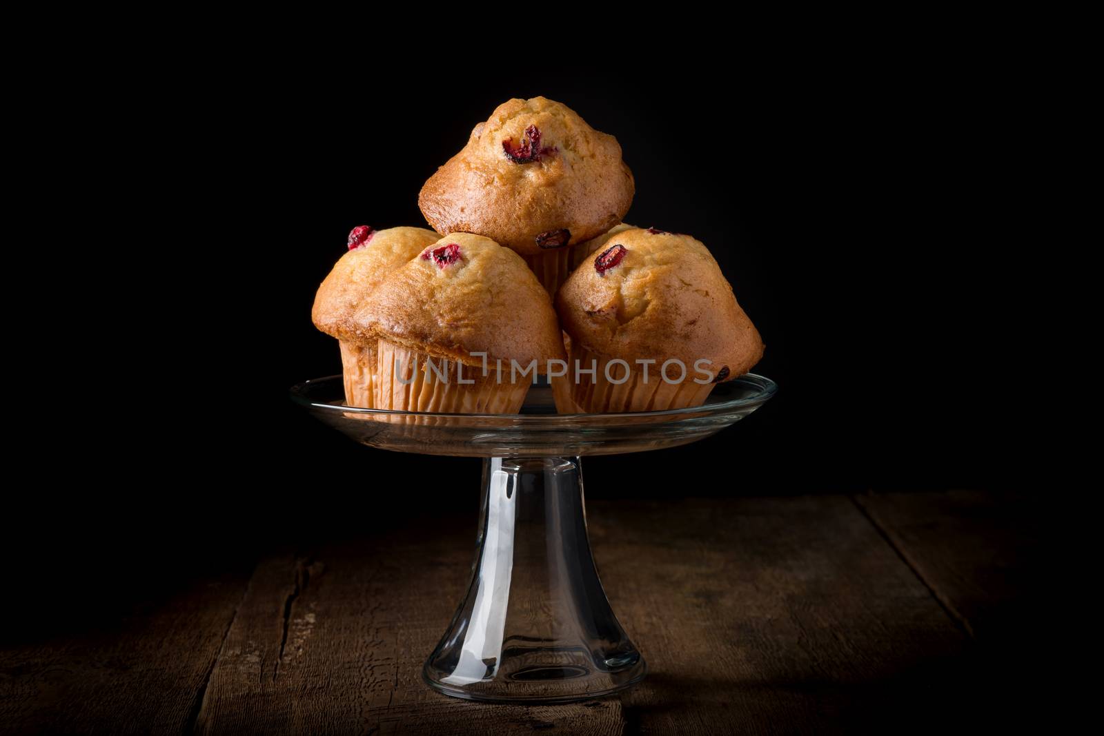 Fresh lemon cranberry muffins on a low key background.