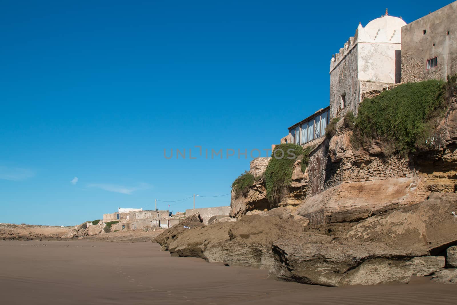 Small mosque in the village on the coast of Atlantic Ocean in Morocco, Moulay Bouzerktoun. Bright blue sky.