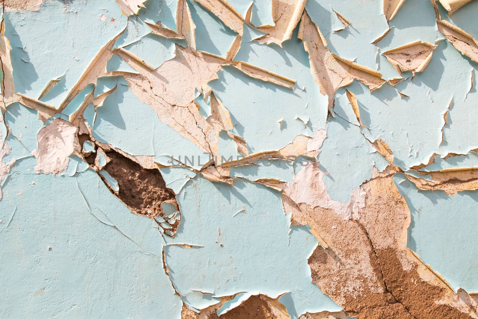 Detail of an old wall, painted blue, with peeling off painting.