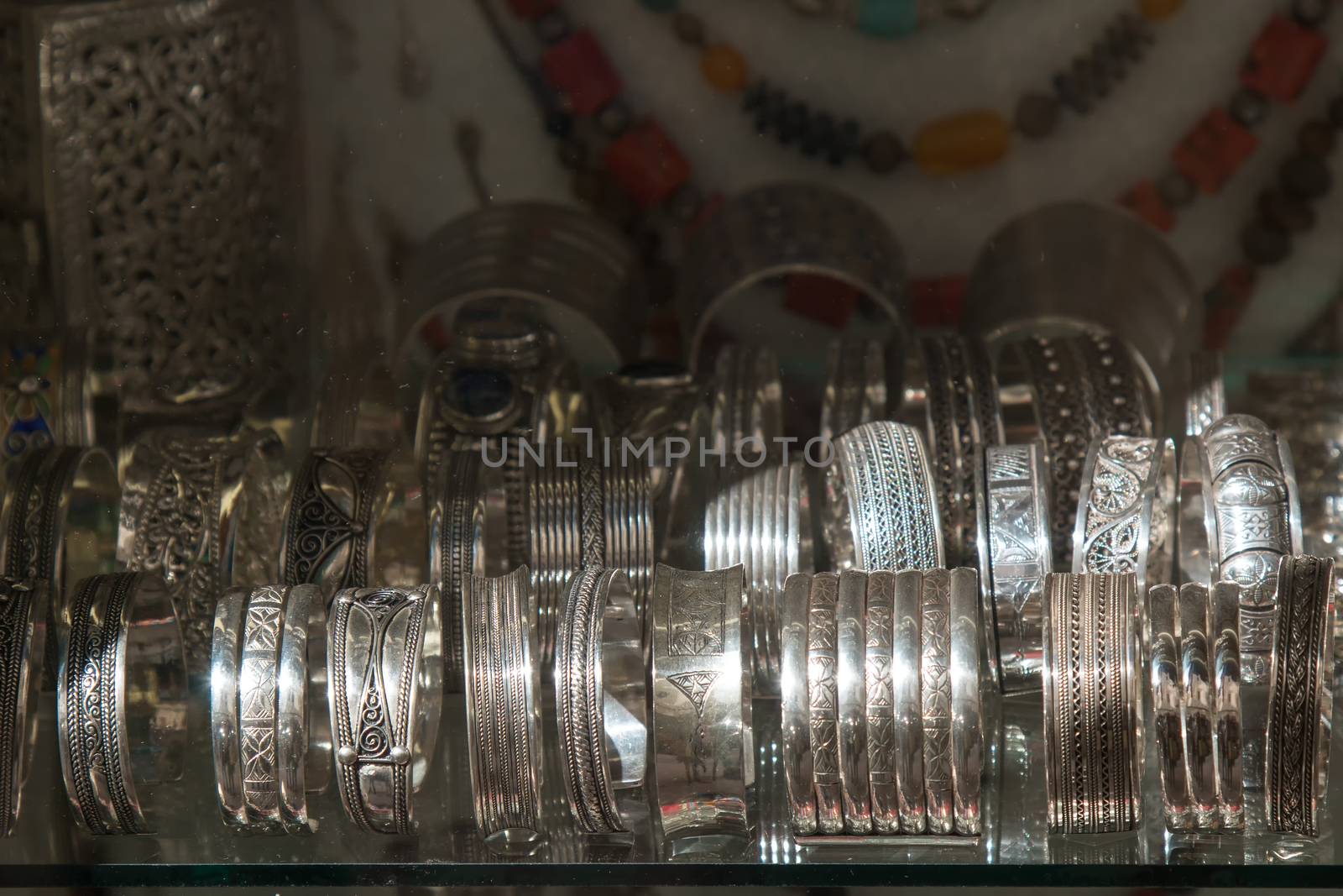 Silver engraved traditional bracelets in moroccan shop. Necklaces in the background.