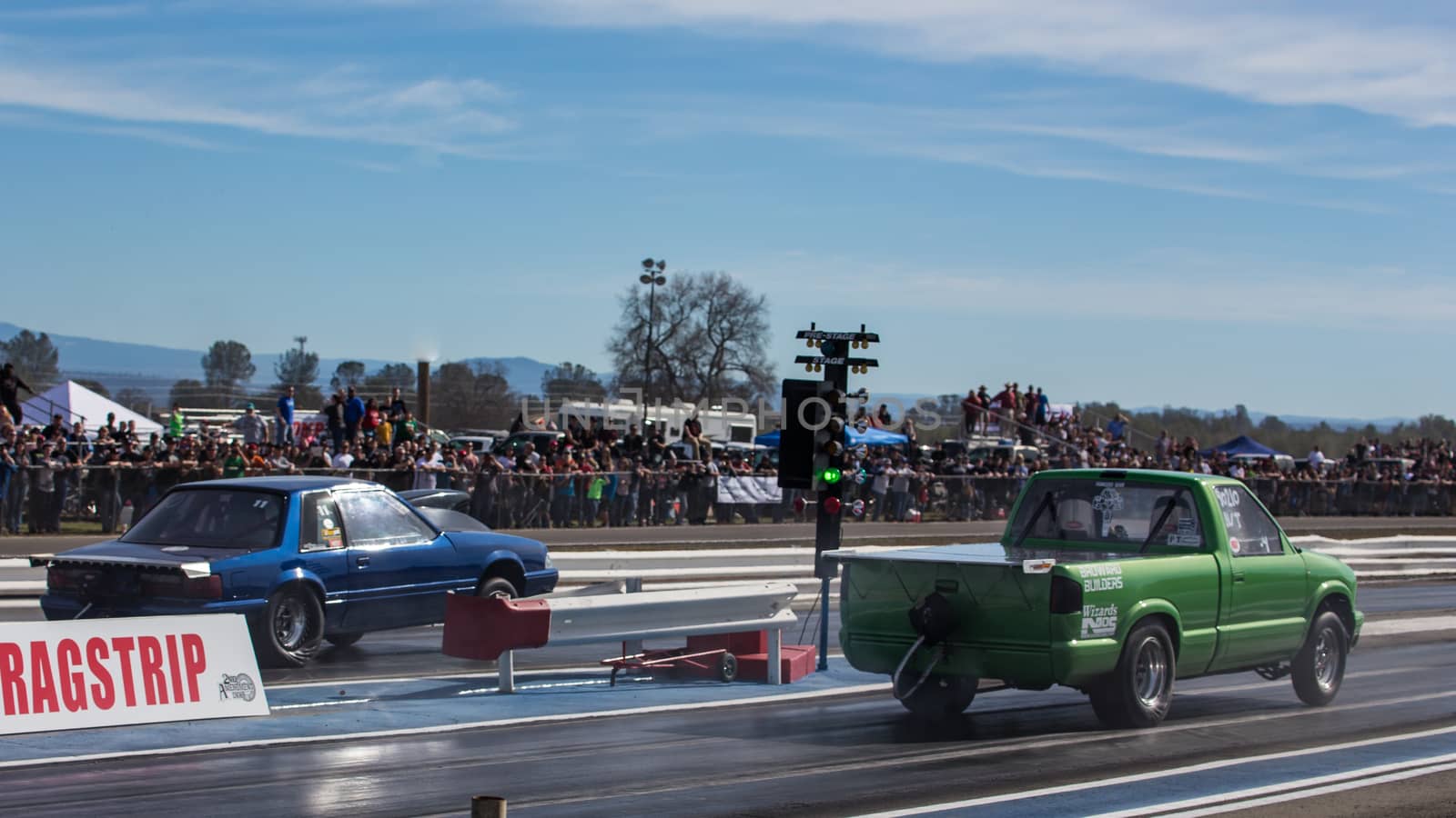 Redding, California: A small green pickup truck and a blue hot rod get the green light to start during a drag light.
Photo taken on: February 13th, 2016