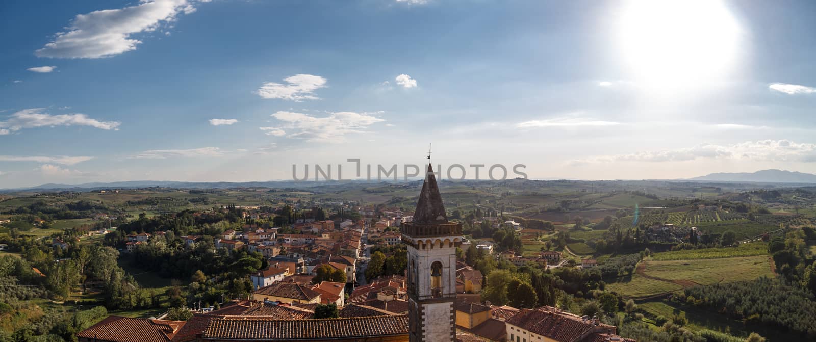 Panoramic top view of Vinci Village around meadow area from Conti Guidi Castle in Italy, under bright blue sky background.