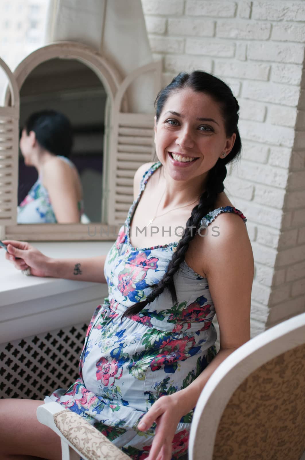 Smiling pregnant woman near the mirror by Linaga