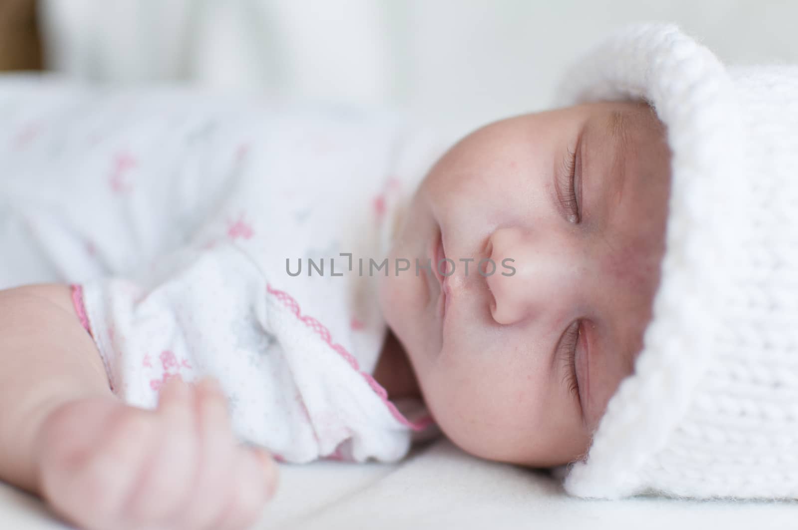 Sleeping baby in white hat by Linaga