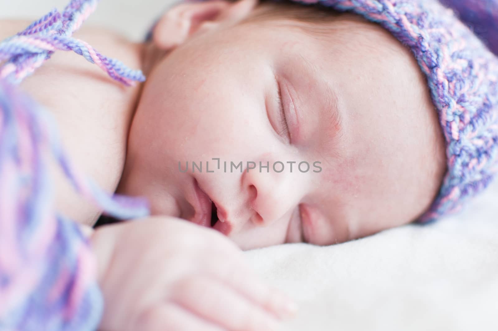 Horizontal portrait of the sleeping baby in purple hat