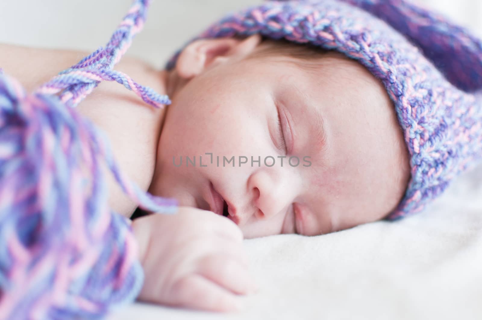 Sleeping baby in purple hat closeup portrait by Linaga