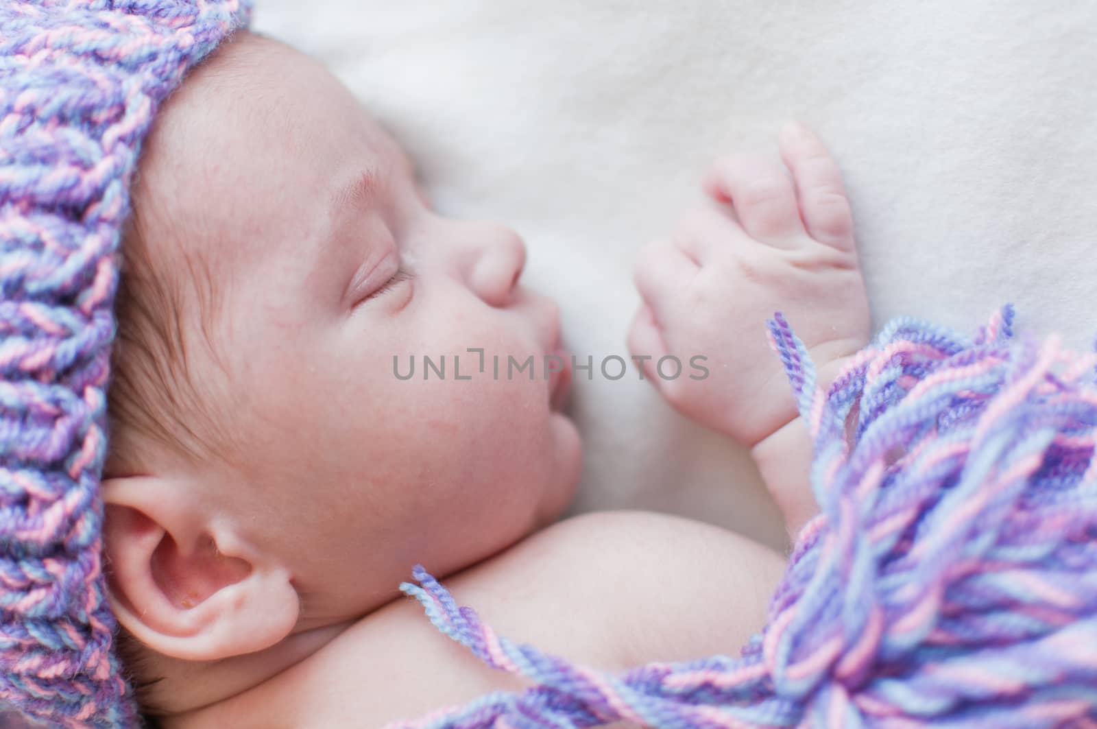 Horizontal portrait of the sleeping baby in purple hat
