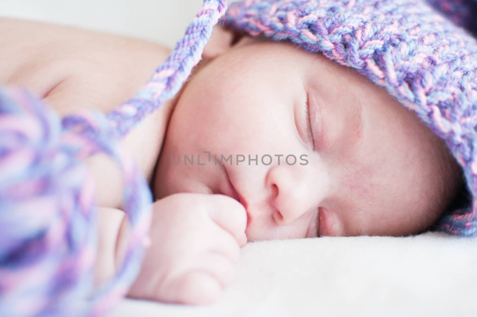 Sleeping baby in purple hat closeup portrait by Linaga