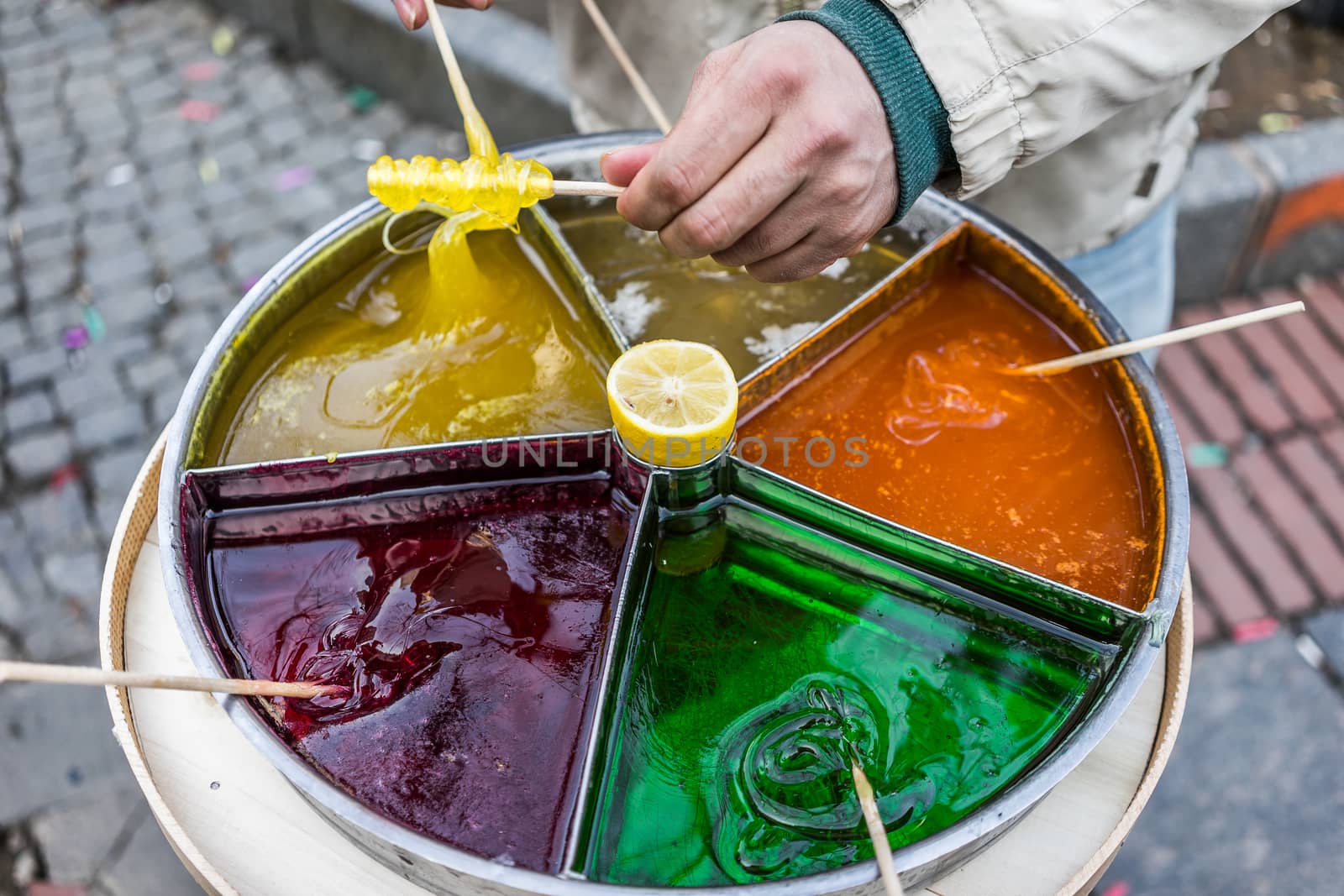 A shot of a person preparing sticky candy on a stick.
