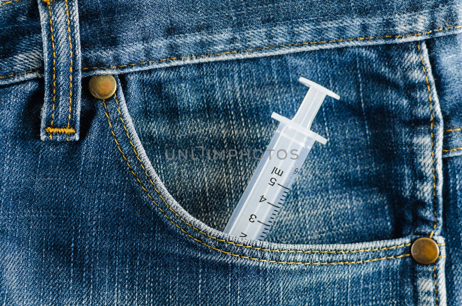 Syringe in the pocket of a blue jeans