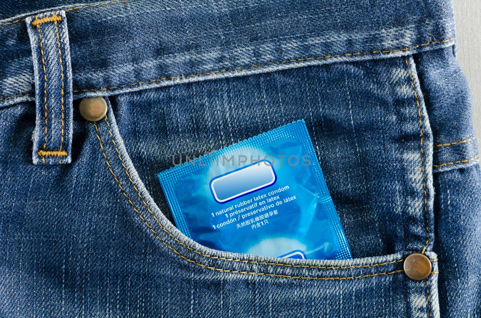 condom in the pocket of a blue jeans by nop16