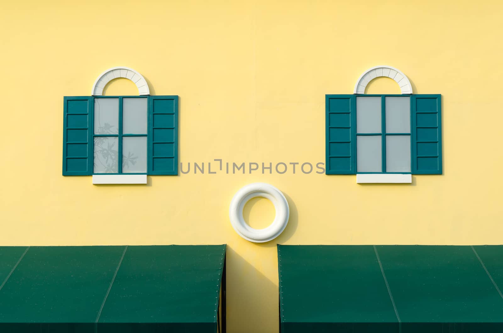 Vintage green window on the yellow wall.