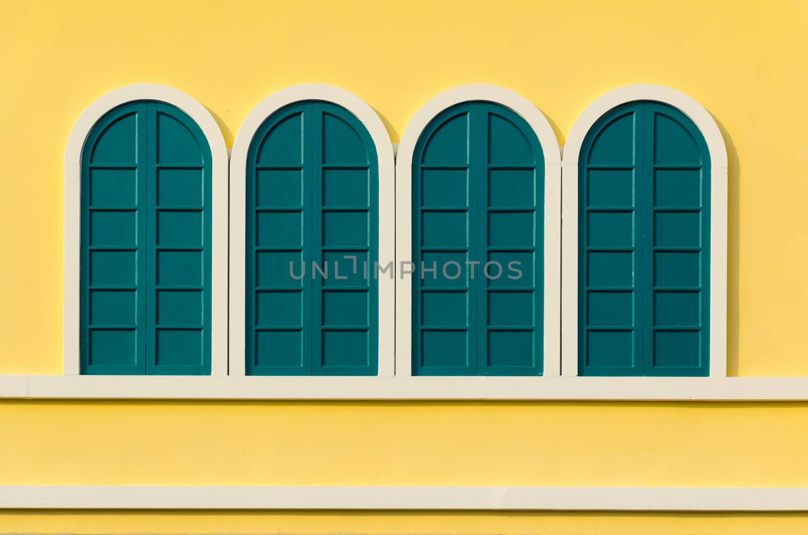 Vintage green window on the yellow wall.