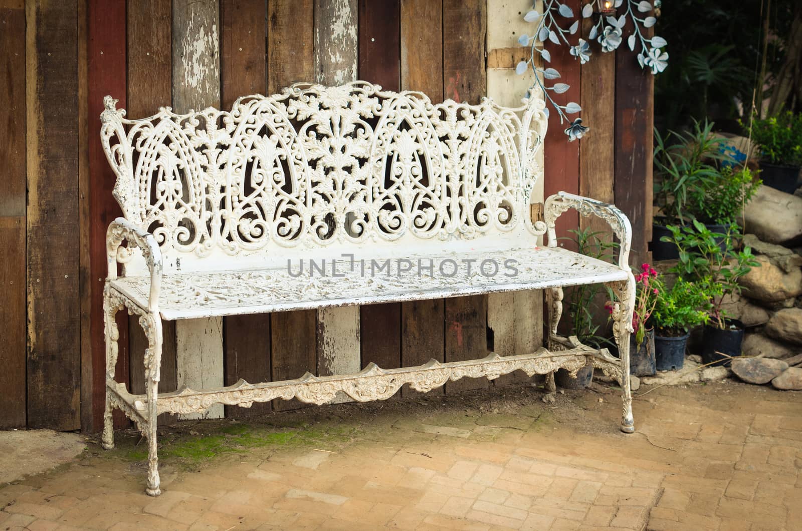 Vintage white steel bench with wooden plank background