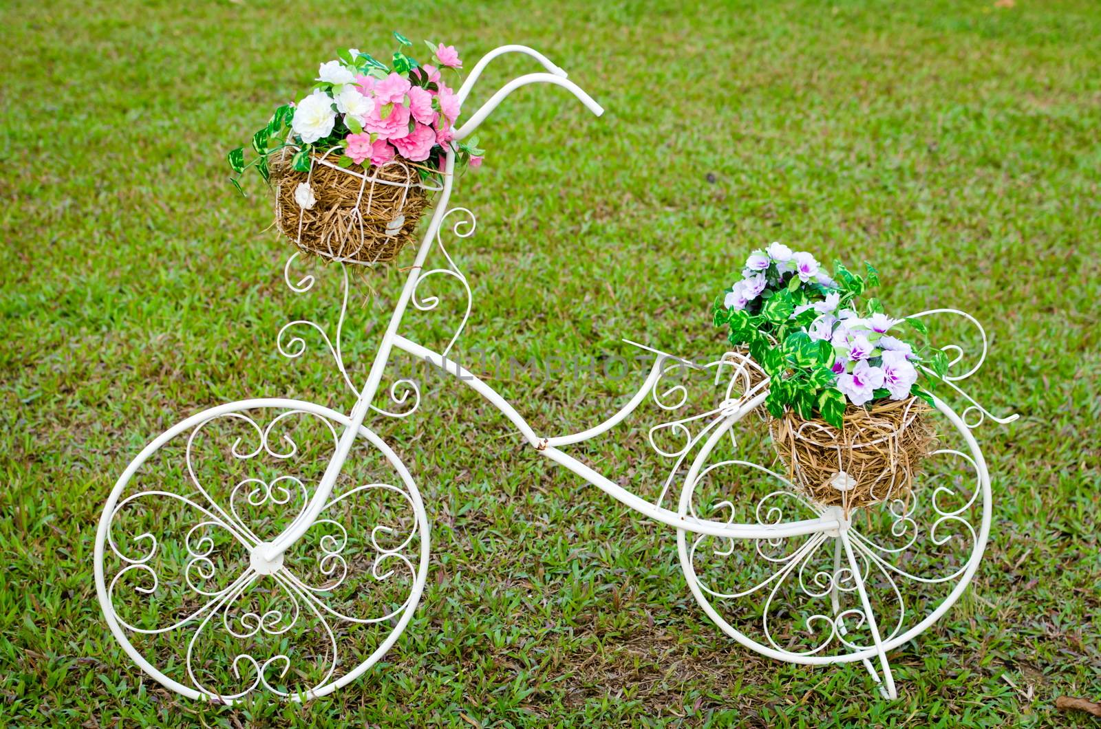 White steel bike and flower pots on the grass