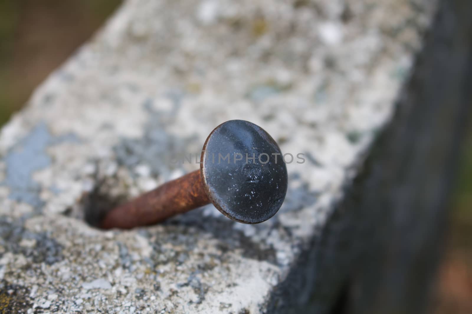 Bent Rusted Nail in the Concrete by YassminPhoto