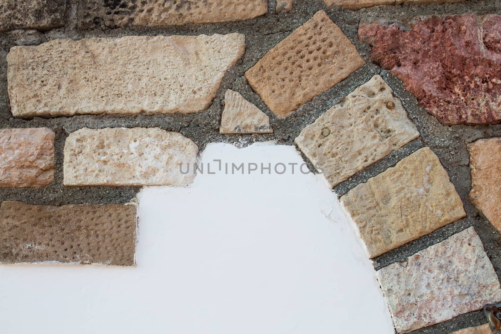 Wall of a building with decoration made of colorful bricks. From beige, orange to red color.