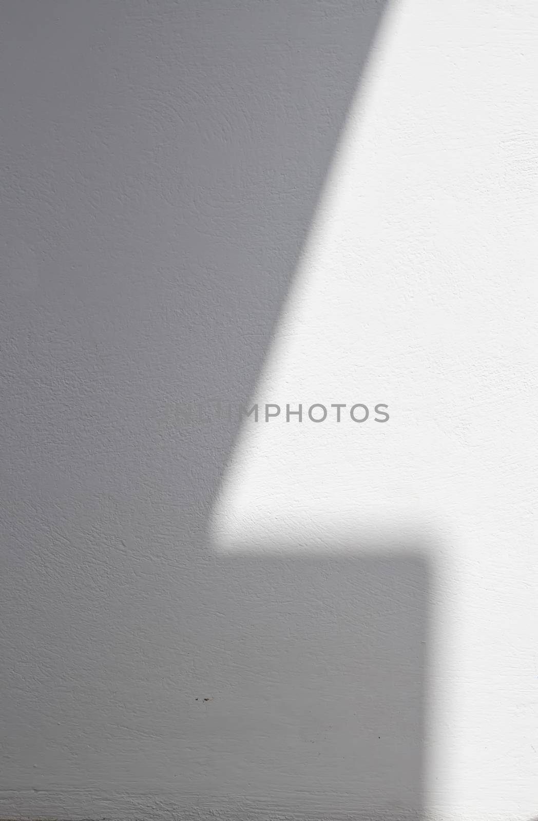 Border of a light and shadow, creating a bright number one on the white wall.