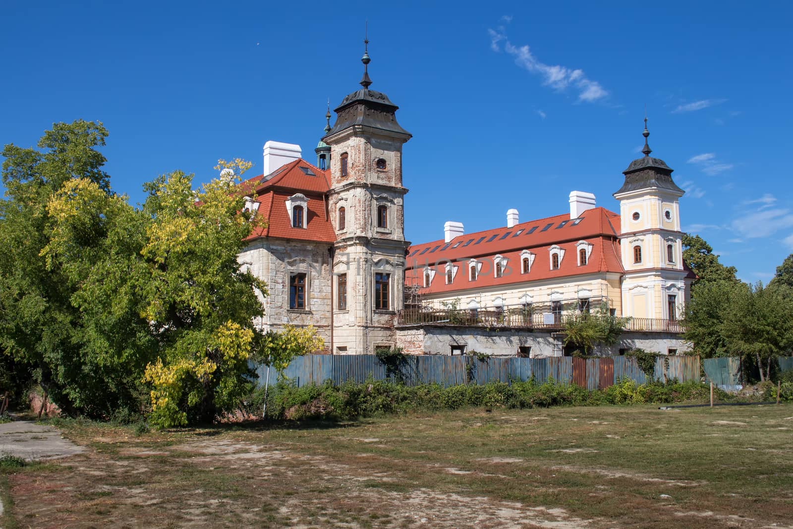 Partly rebuild manor-house, located in a city Bernolakovo. Old towers and new roof. Blue sky with some clouds.