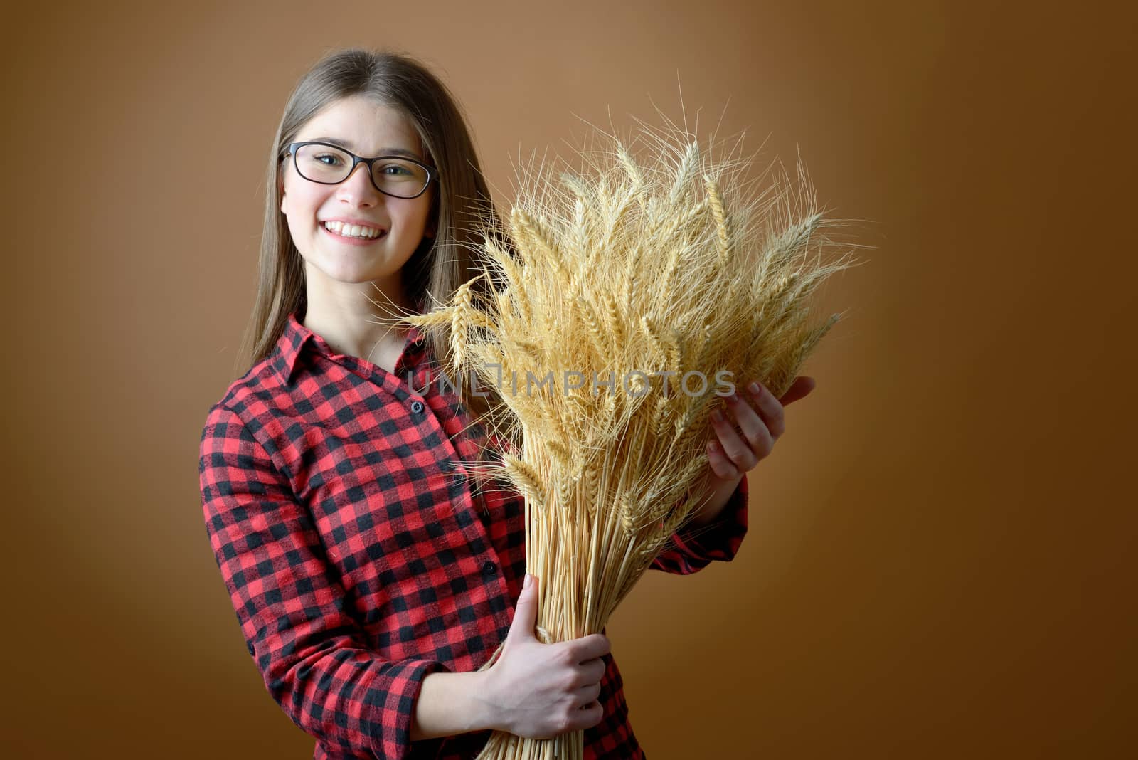 teen girl hold in hand bunch of wheat stalks