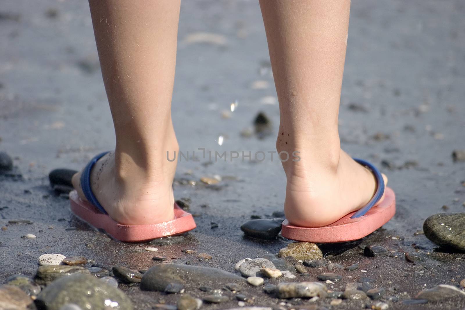 Childish legs on the beach by miradrozdowski