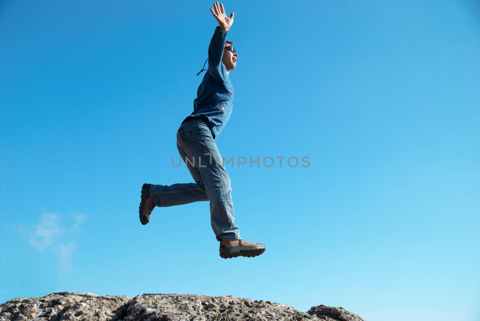 Man jumping on the rocks with landscape background