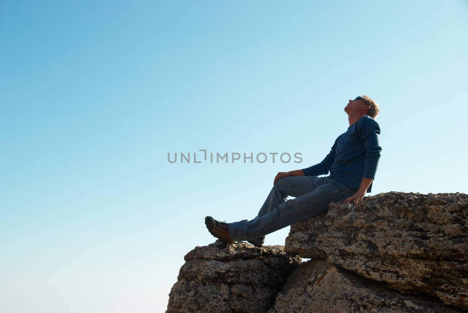 Man gesturing on the rock by vapi