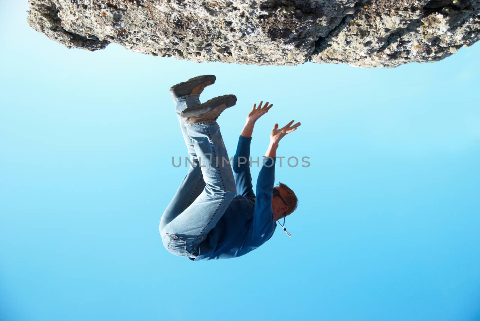 Falling down man from the rock with blue background