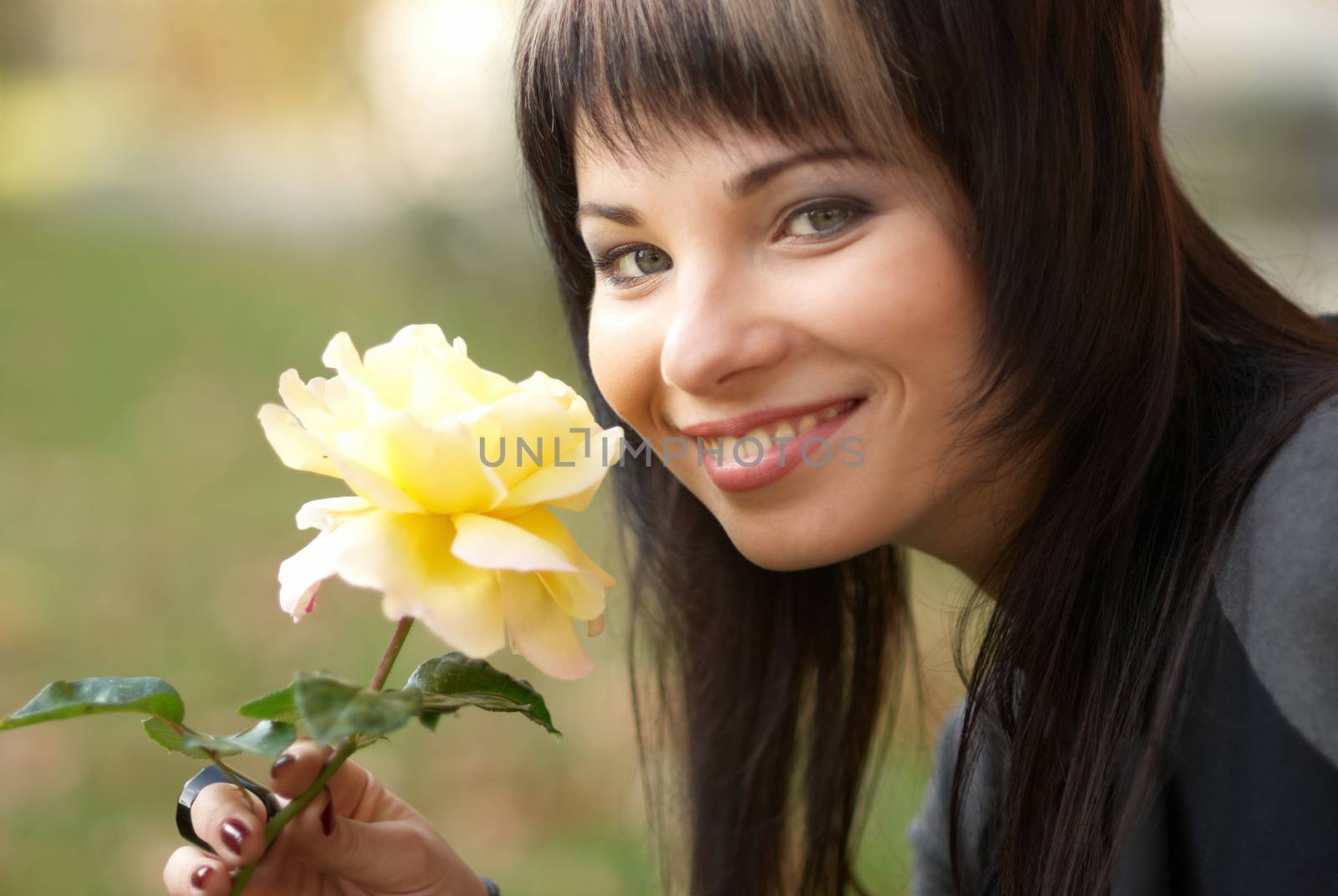 Beautiful girl with yellow rose, sofr background