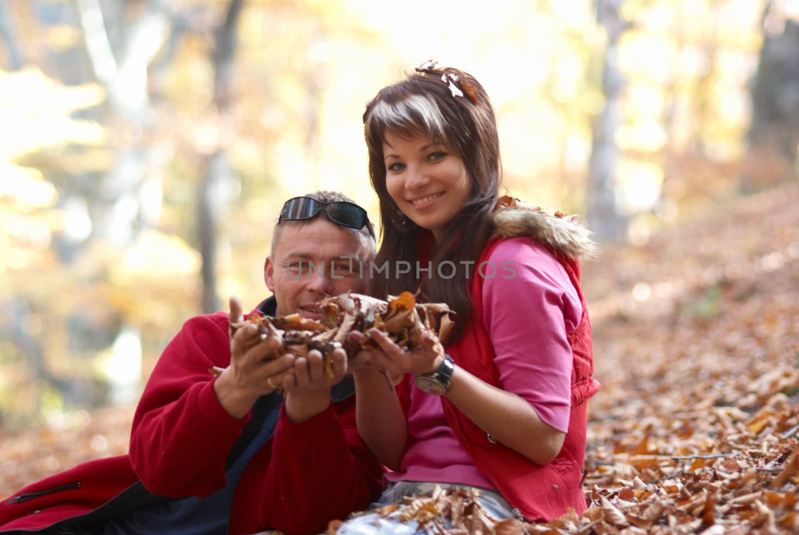 Young couple enjoying the falling leaves by vapi