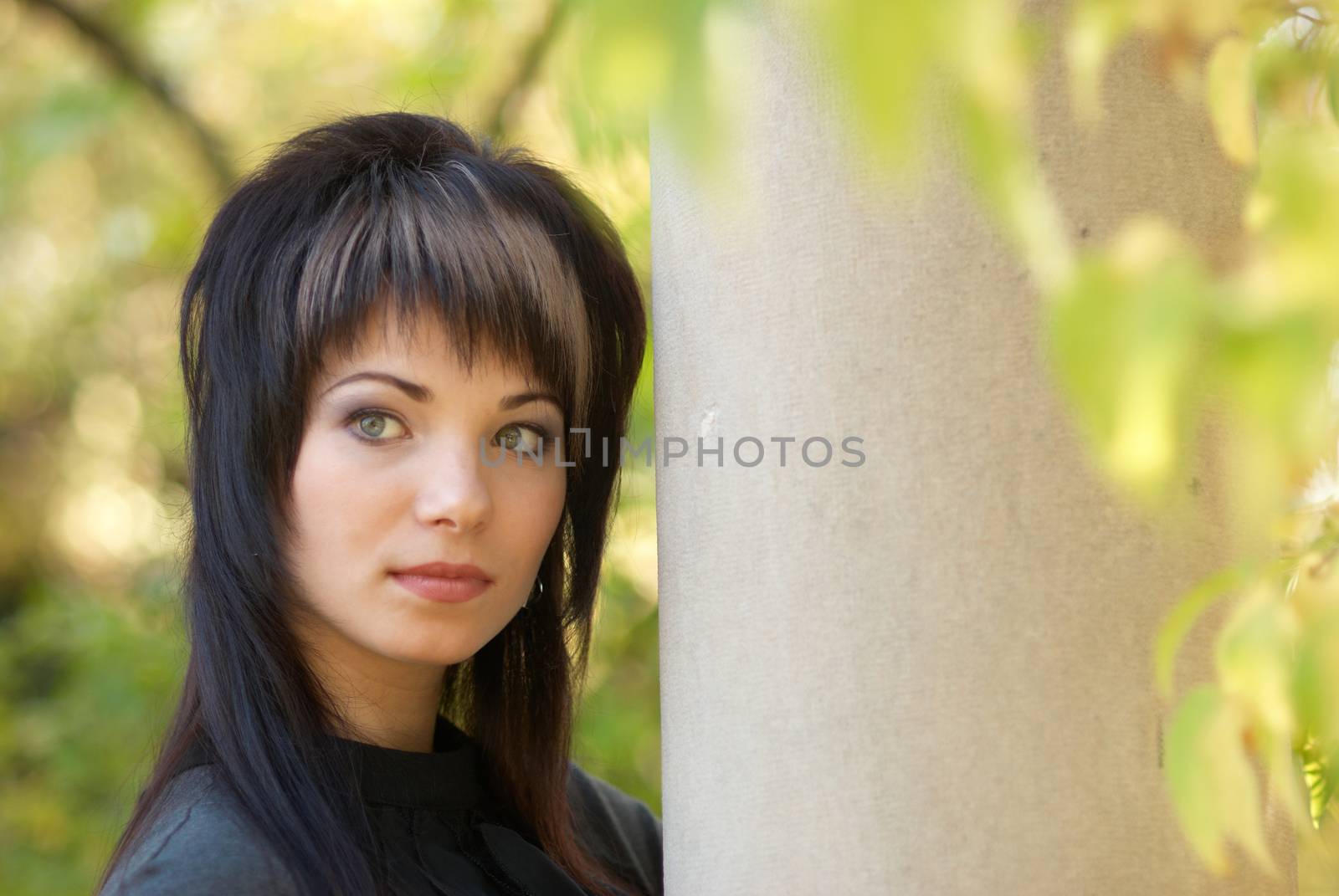 Beautiful girl's portrait near the column with soft background