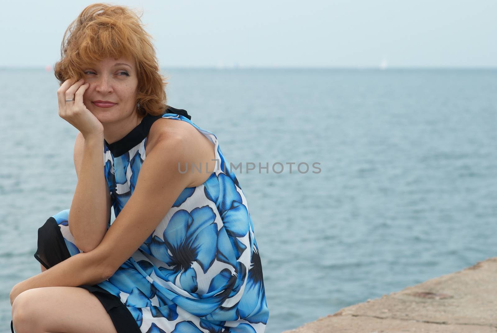 Beautiful woman sitting on the mooring with blue background