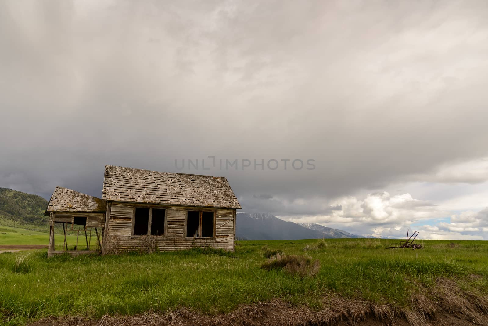 Old abandoned farm in Wyoming, United States. Spring with cloudy sky.