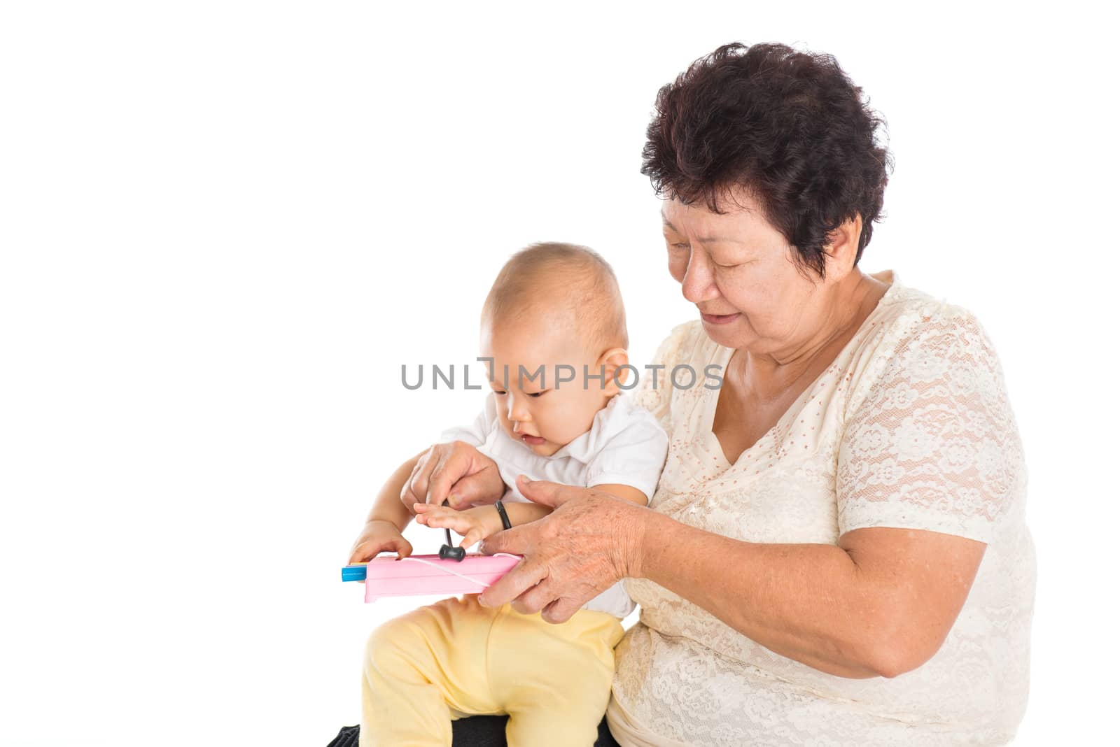 Grandmother and grandson playing musical instrument together, baby sound development concept,  isolated on white background.