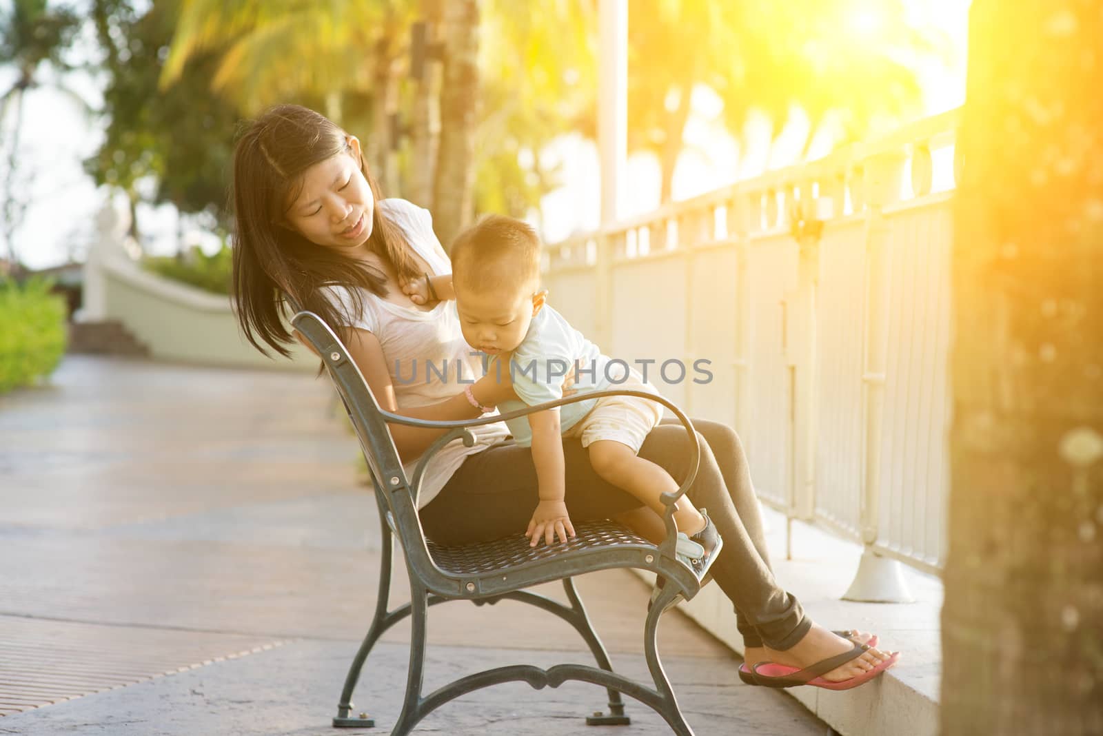 Mother and son having fun at outdoor in sunset during vacation.