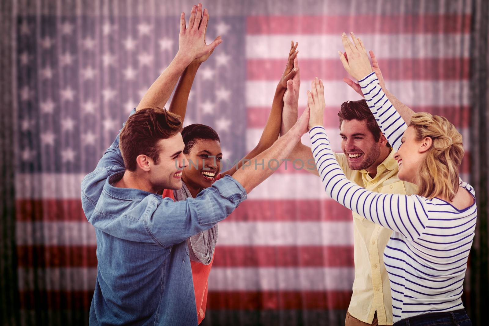 Happy creative team giving high fives to each other against composite image of usa national flag