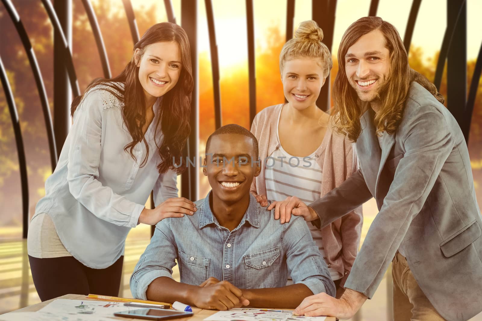 Composite image of portrait of smiling business team putting hands on man shoulder at desk  by Wavebreakmedia