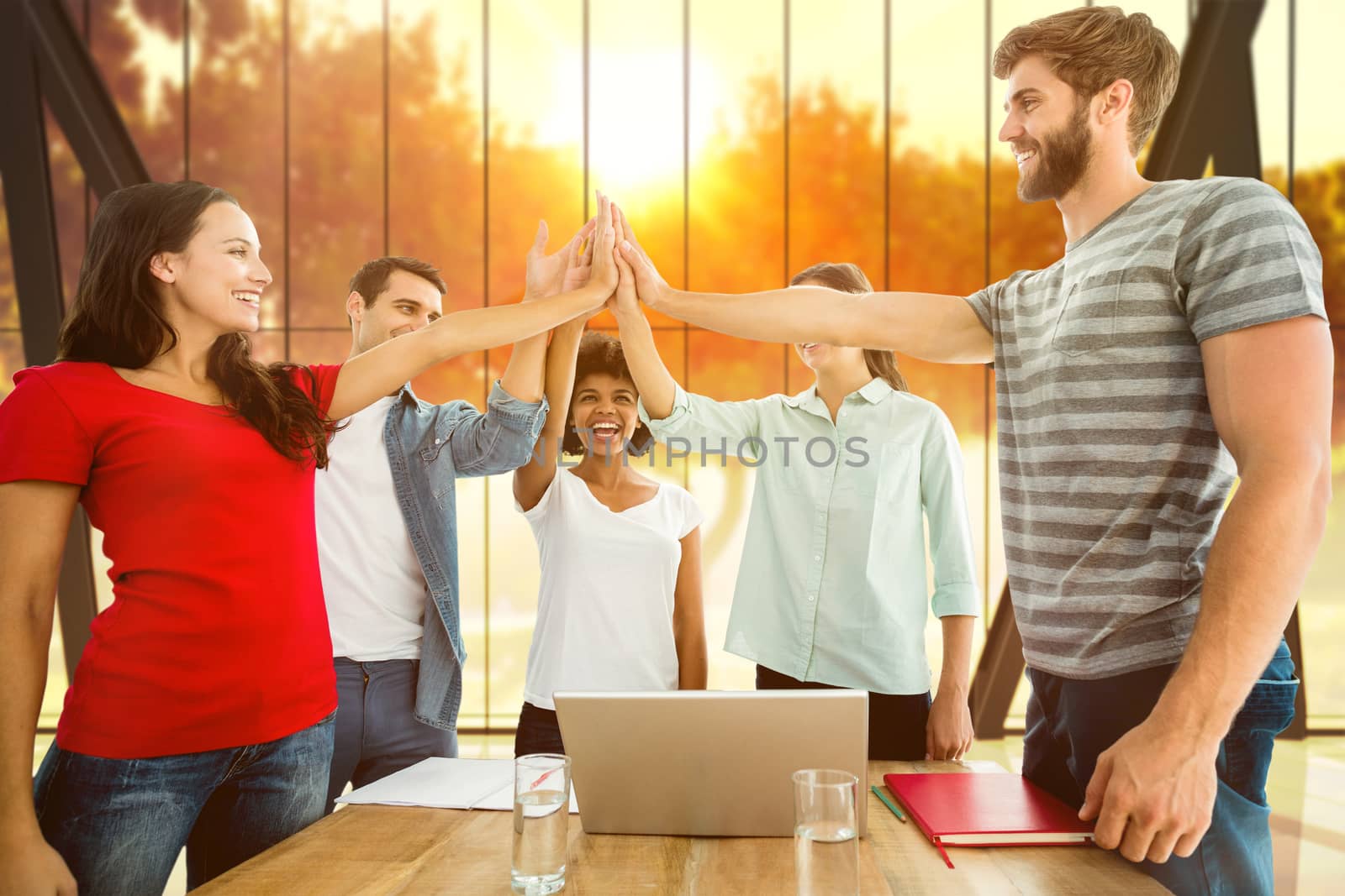 Composite image of happy business team putting their hands together by Wavebreakmedia