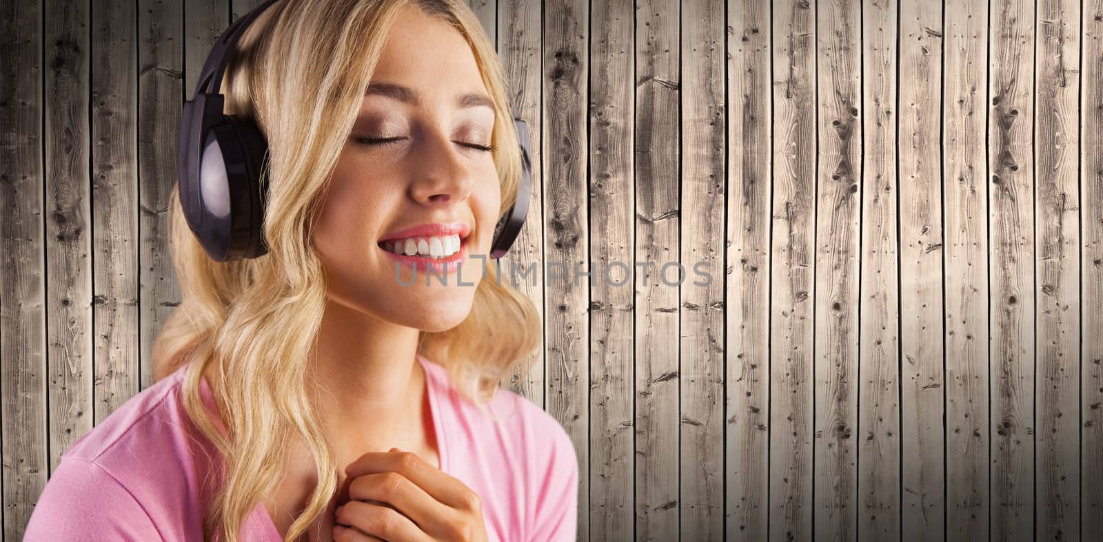 Close up of a woman listening to music  against wooden planks background