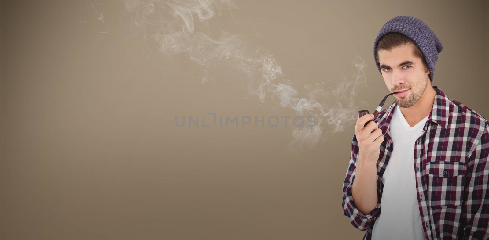Portrait of  confident hipster holding smoking pipe against grey background with vignette