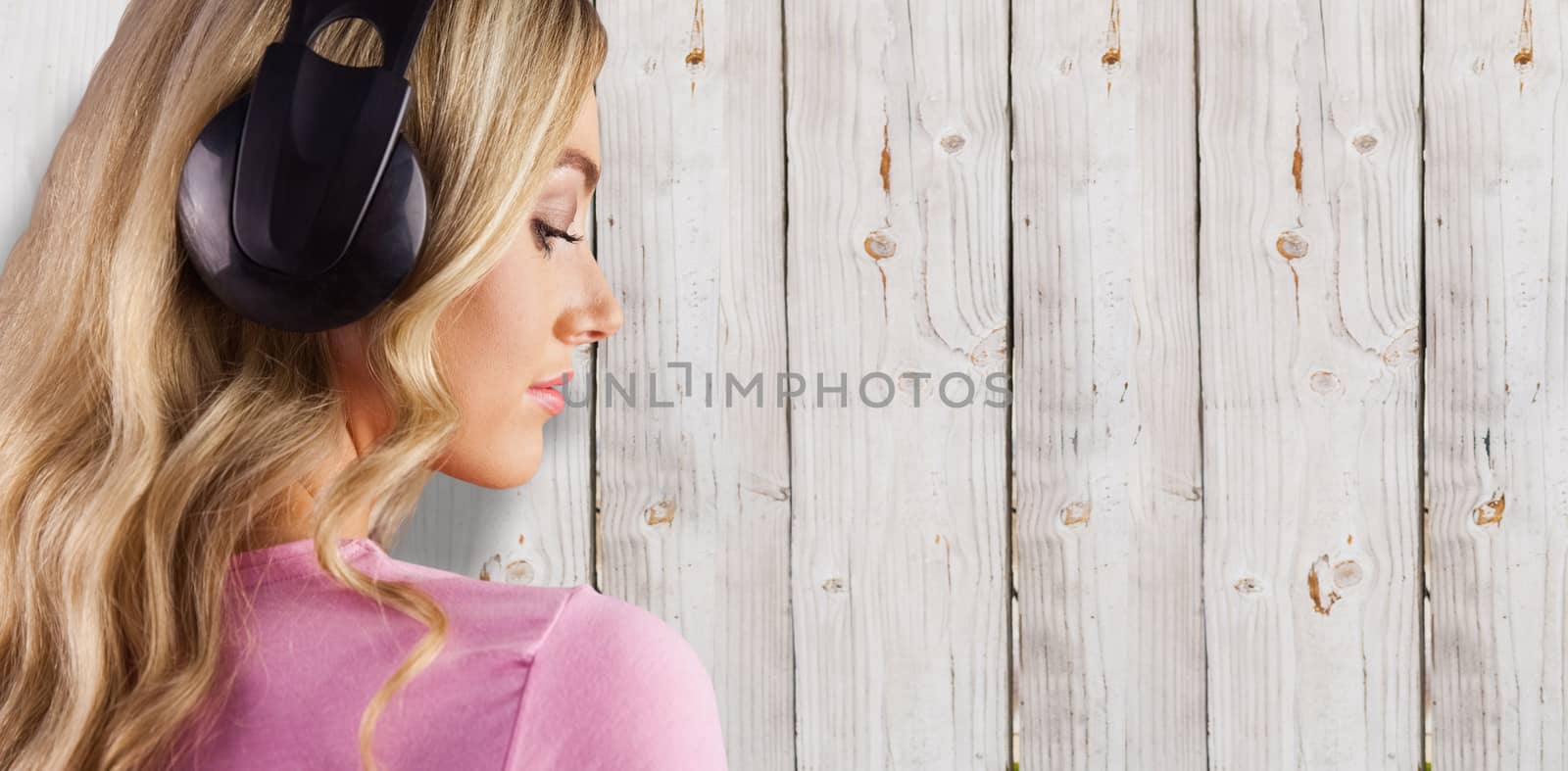 Close up of a woman listening to music  against wooden background