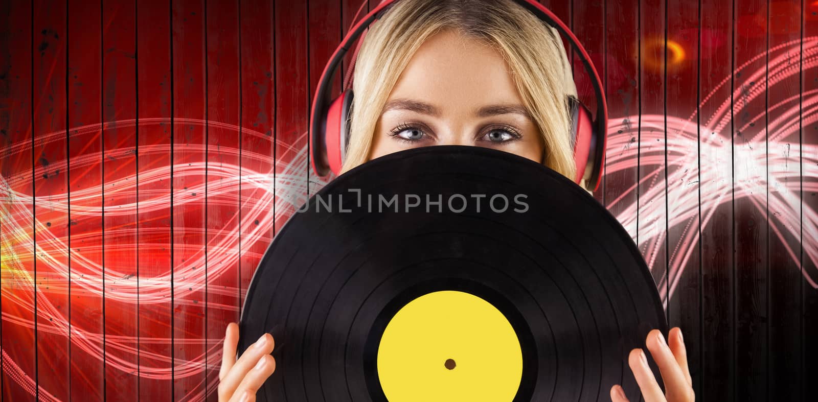 Portrait of a beautiful woman holding a vinyl  against curved laser light design in red