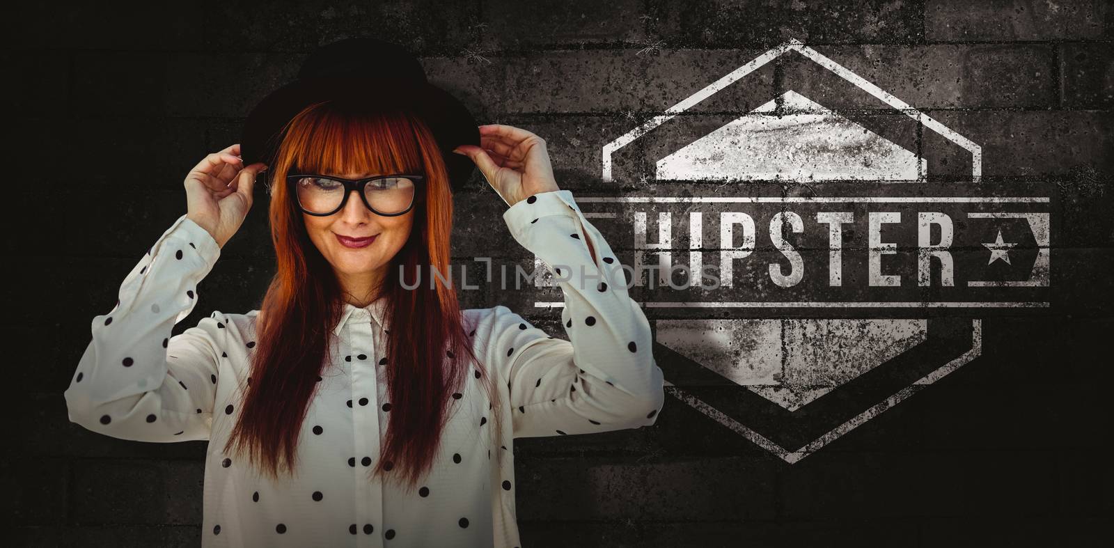 Attractive smiling hipster woman with hat  against texture of bricks wall