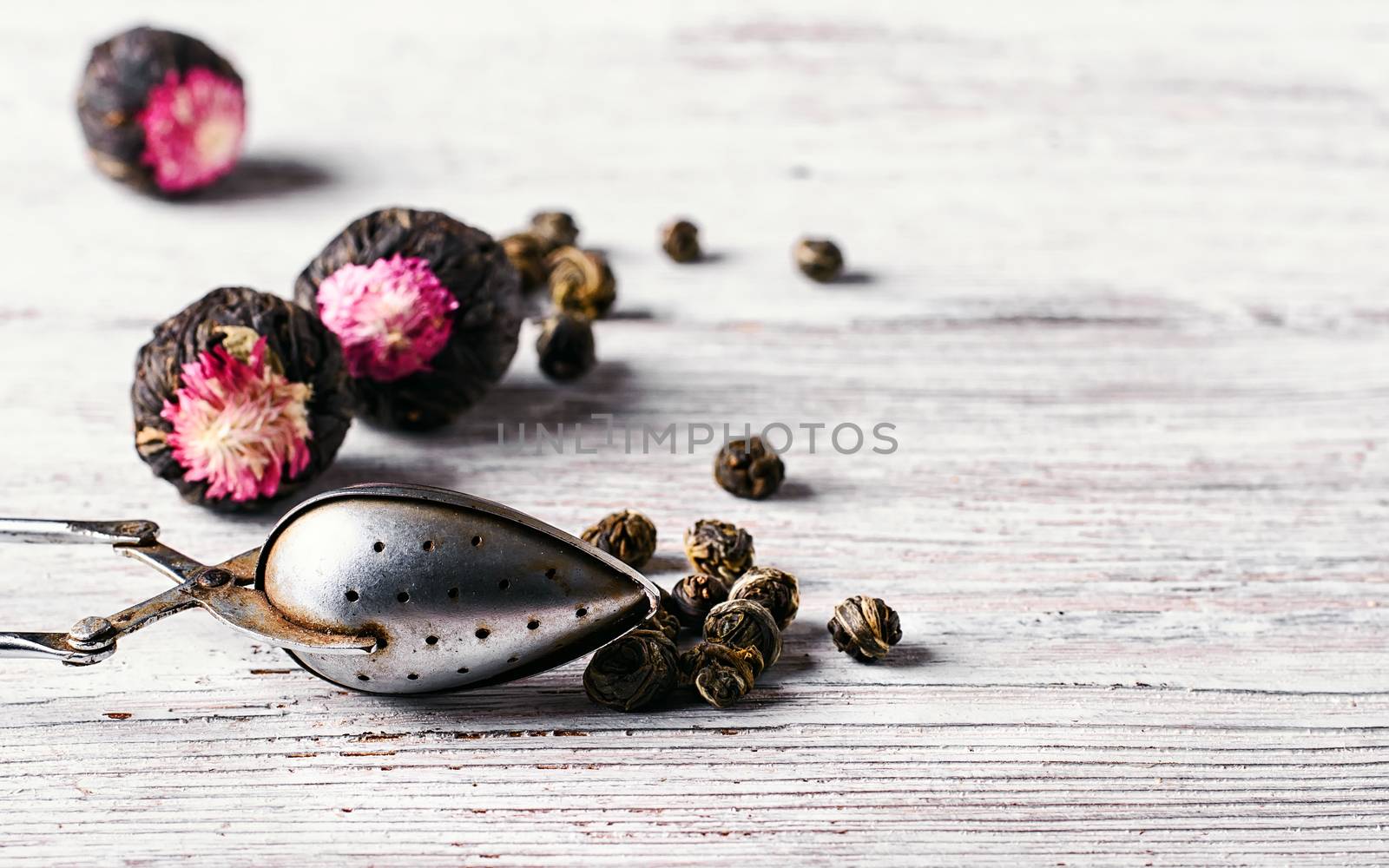 Several types of leaf tea light on a bright wooden background.