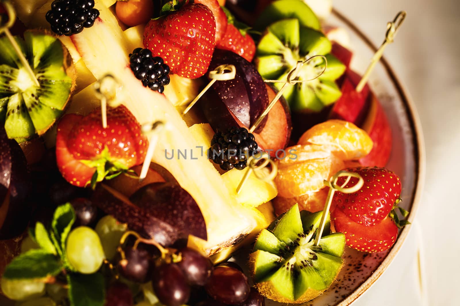 Fresh juicy fruits and berries on a plate