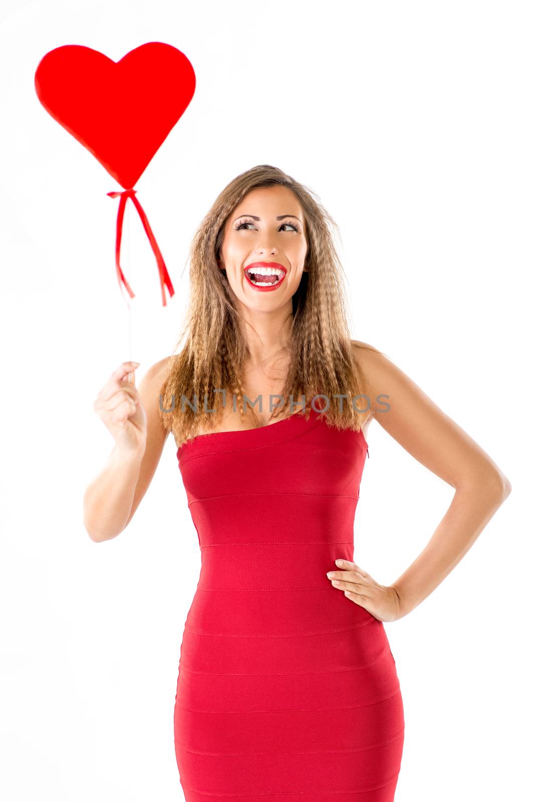 Beautiful cheerful girl standing and holding red heart.