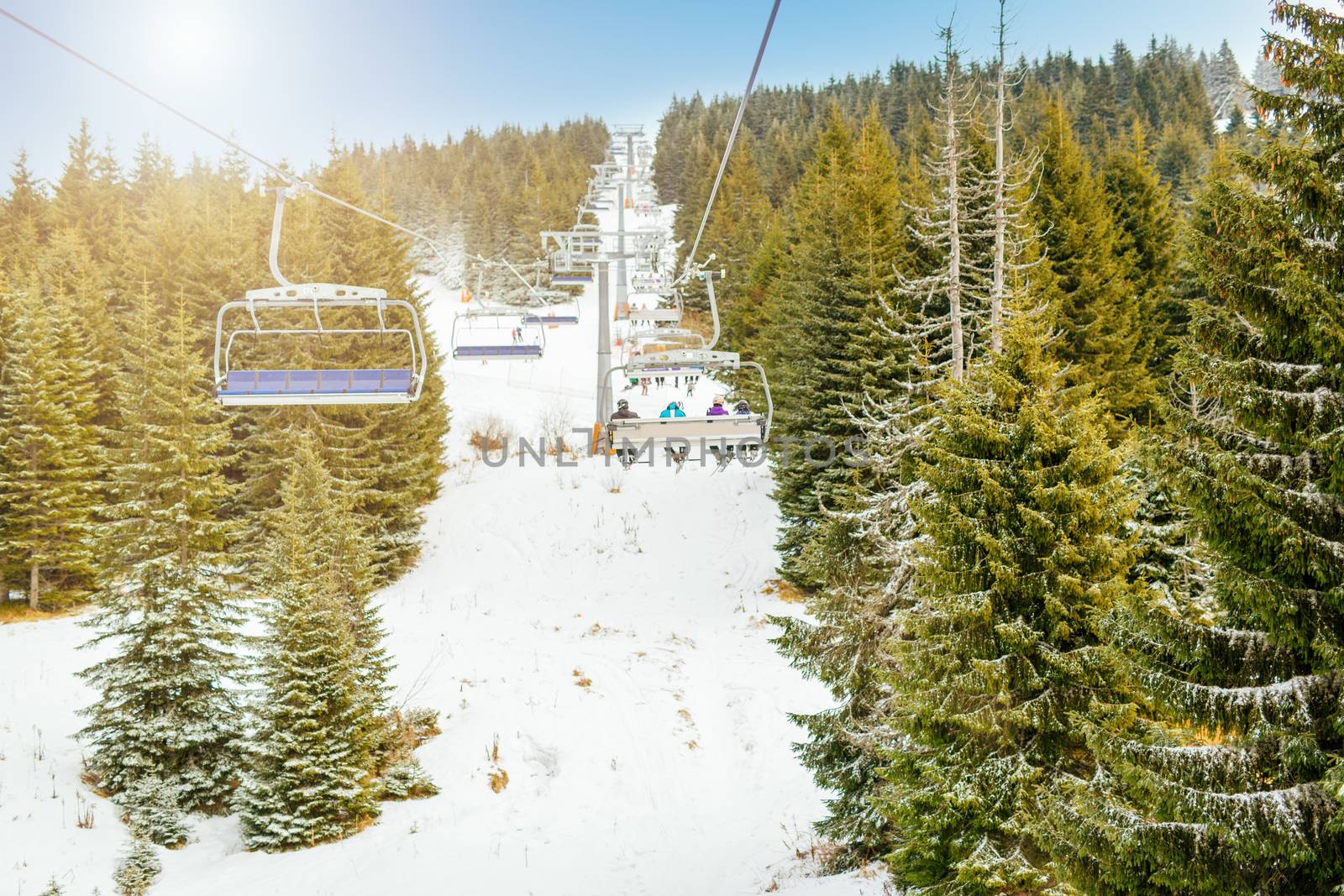 Ropeway and chair lifts in driving at ski resort in nice sunny day. Landscape.