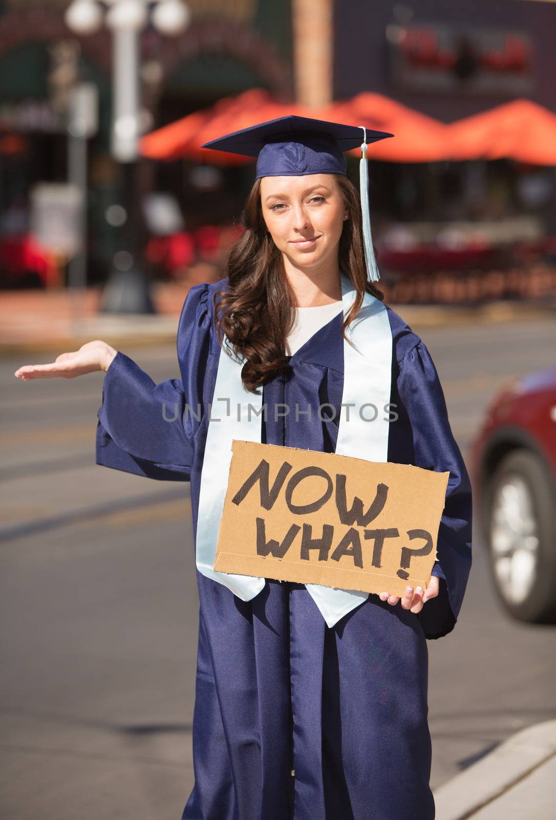 Grinning woman with hand out holding now what? sign