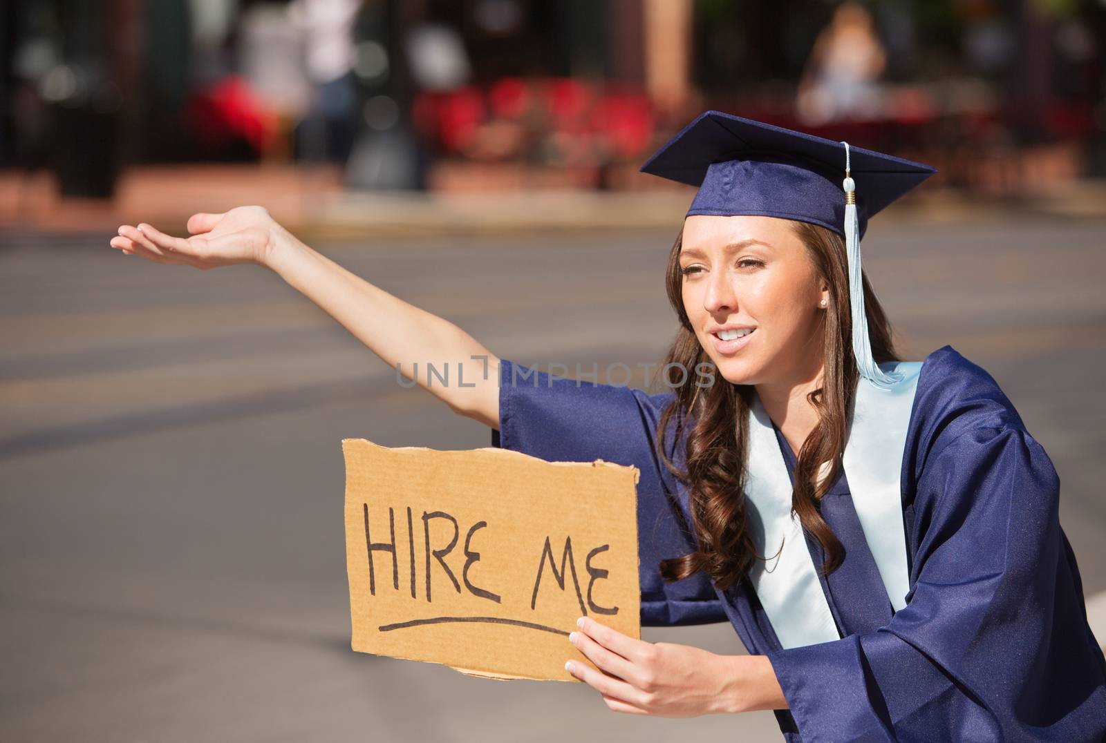 Graduate with Hire Me Sign by Creatista