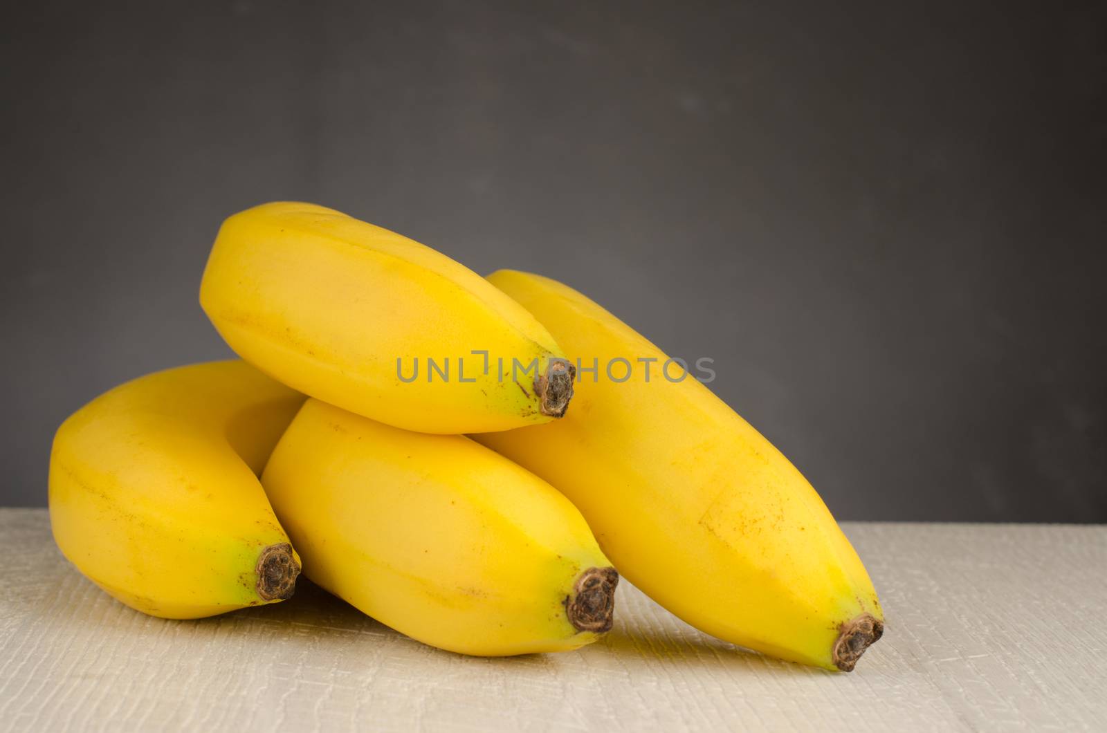 Fresh bananas on wooden background by AnaMarques